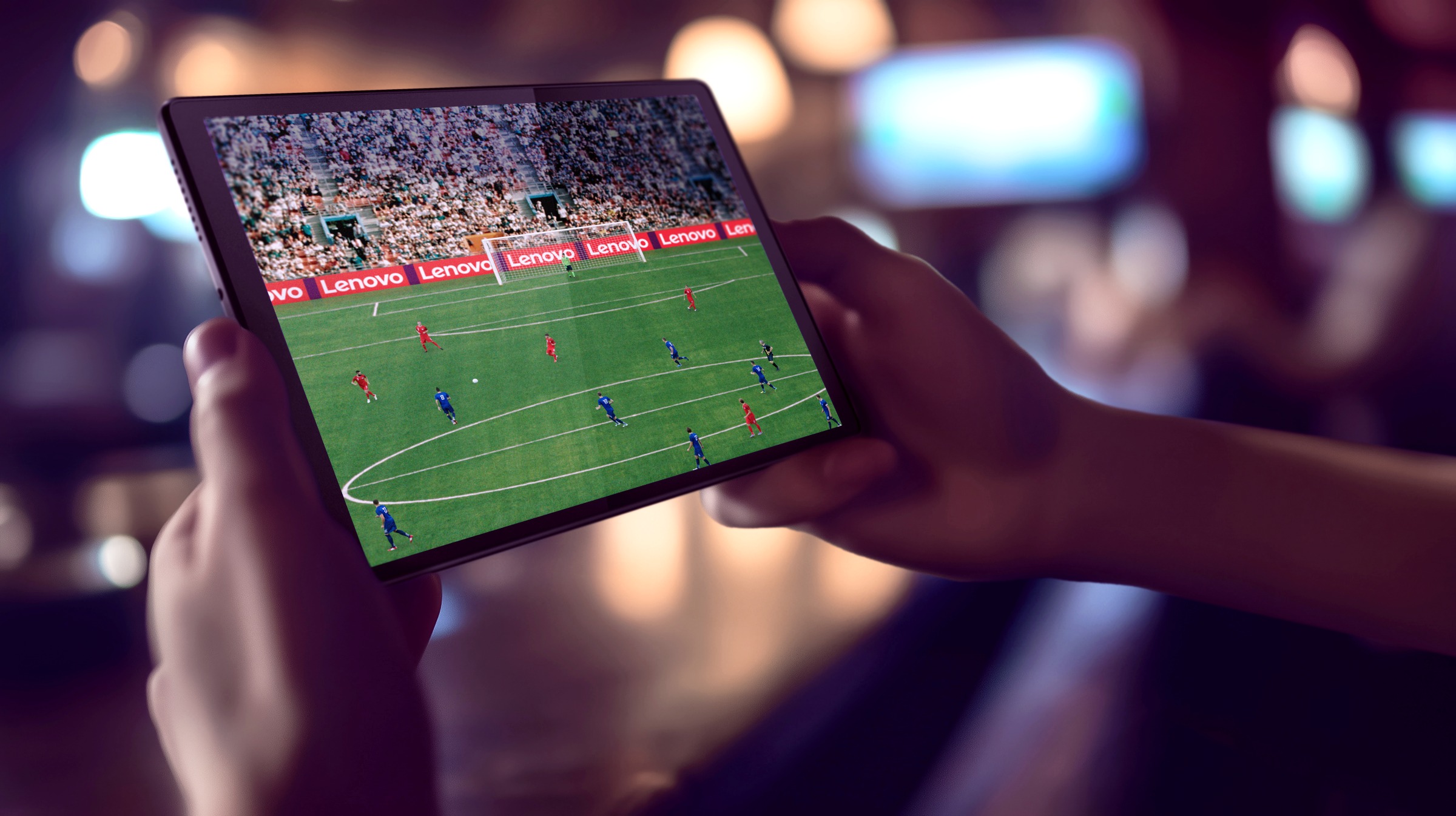 Lenovo Hybrid AI Is Powering Live Sport at Global Scale — From FIFA World Cup 2026 to Formula 1 5 Person watching FIFA match on Lenovo tablet with Lenovo perimeter boards visible
