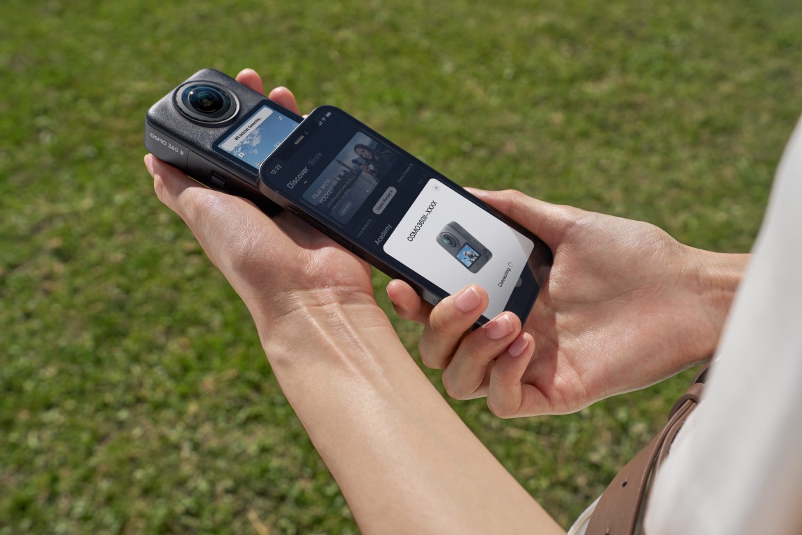 Family using DJI Osmo 360 II selfie stick in meadow